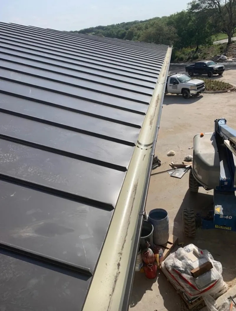 Standing seam panel and gutter detail on a metal roofing jobsite in Abington
